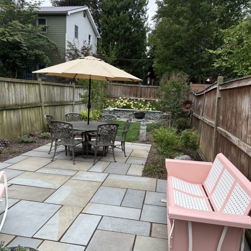 A patio with an umbrella and table in it